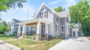 A two-story house with a covered porch, stone steps, and a well-maintained lawn. - Location, Design, Indoor/Outdoor space, close to town and beach! (South Haven)