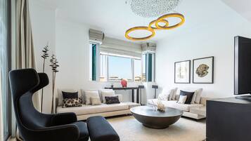 Relax in this stylish living room with a sofa, coffee table, and armchair, offering a view of the city.
