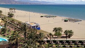 A beach resort with a pool, palm trees, and beach umbrellas. - Evenia Zoraida Resort (Roquetas de Mar)