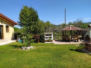 Un patio trasero residencial con una terraza de madera, un mirador y un pequeño jardín.