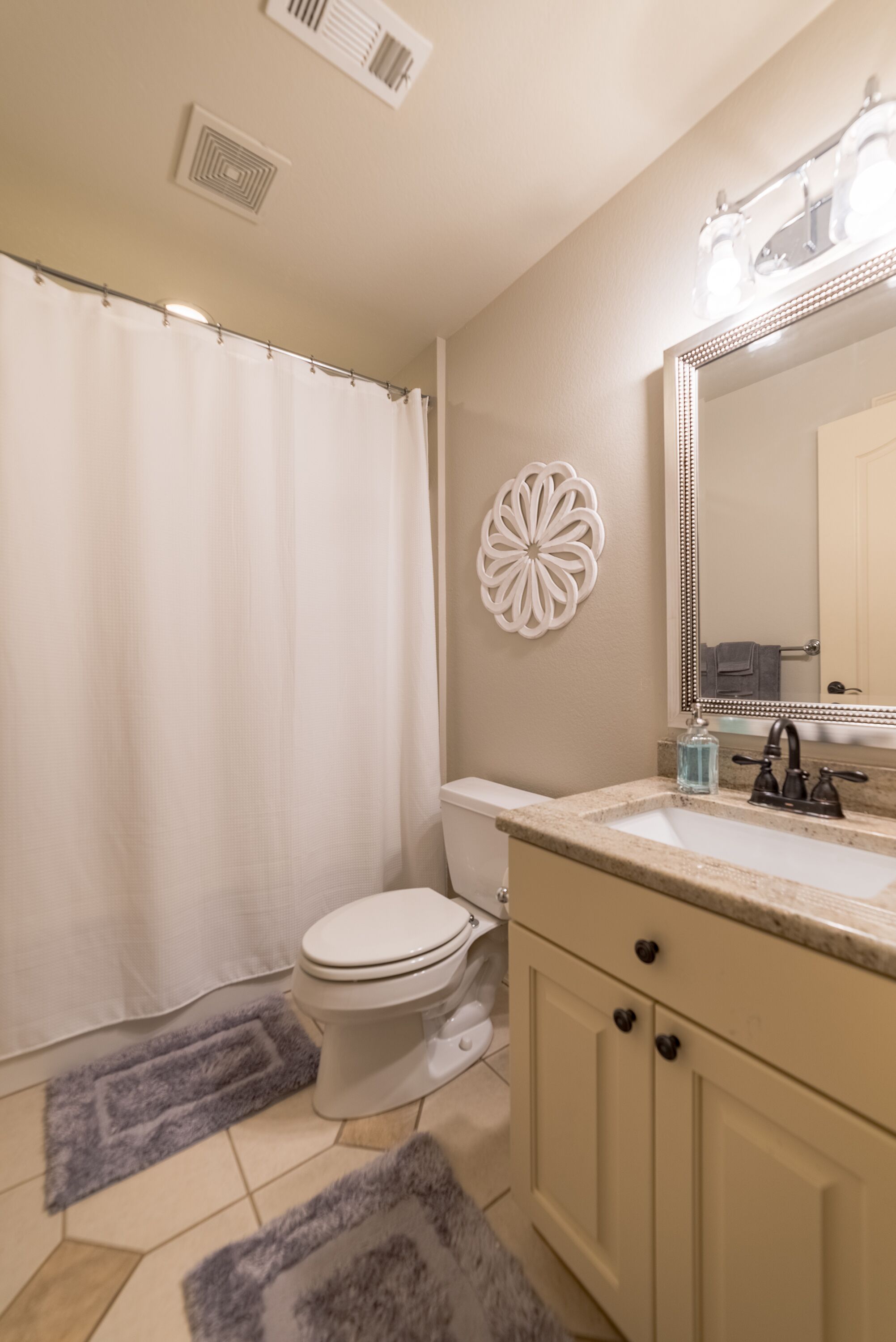 Un baño con inodoro, lavabo y cortina de ducha.