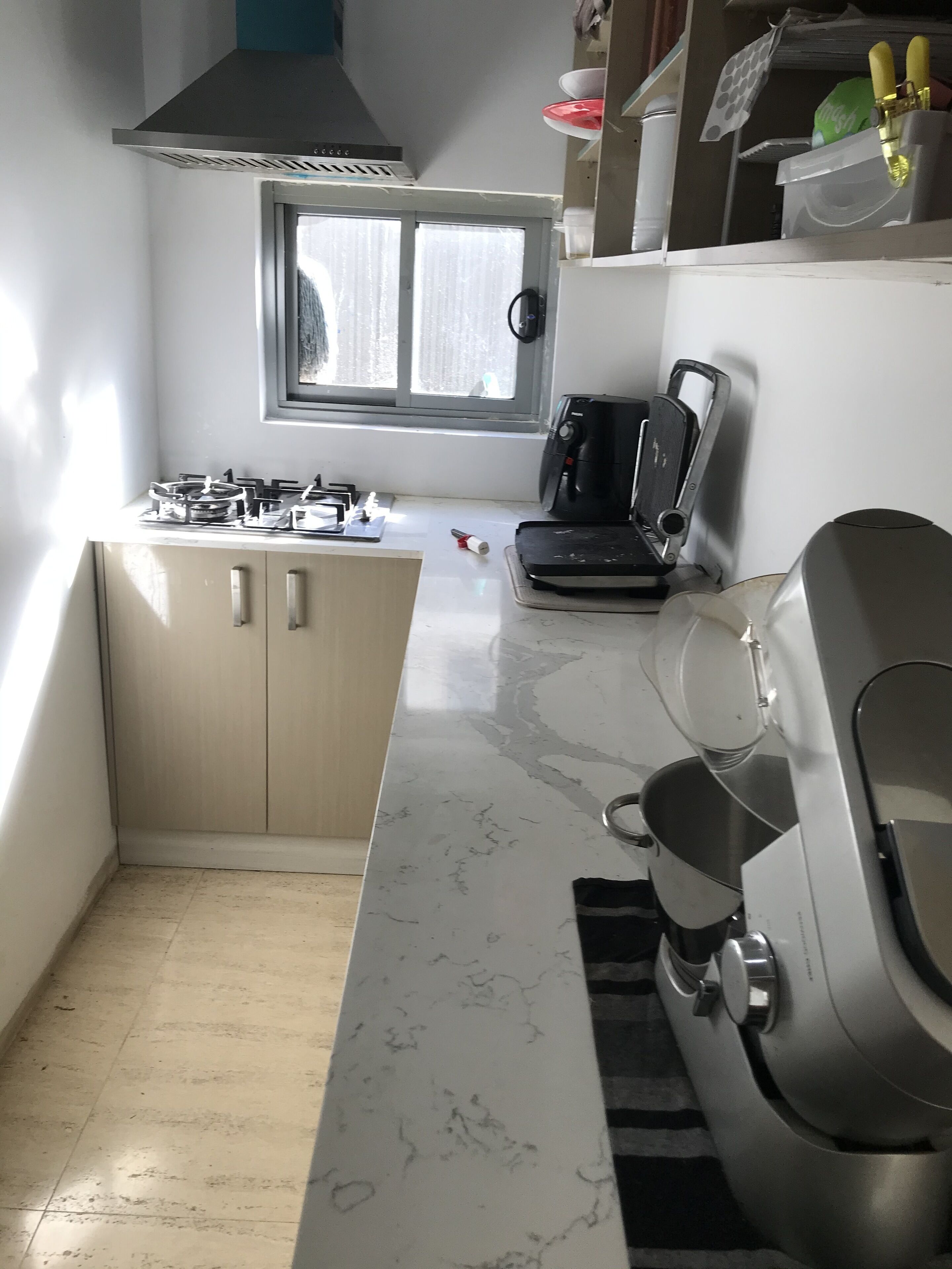 A compact kitchen with a gas stove, a coffee maker, and a microwave.