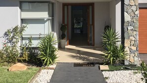 A modern two-story house with a stone facade, a balcony, and a well-maintained garden. - Luxury big house cinema pool many guests (North Rocks)