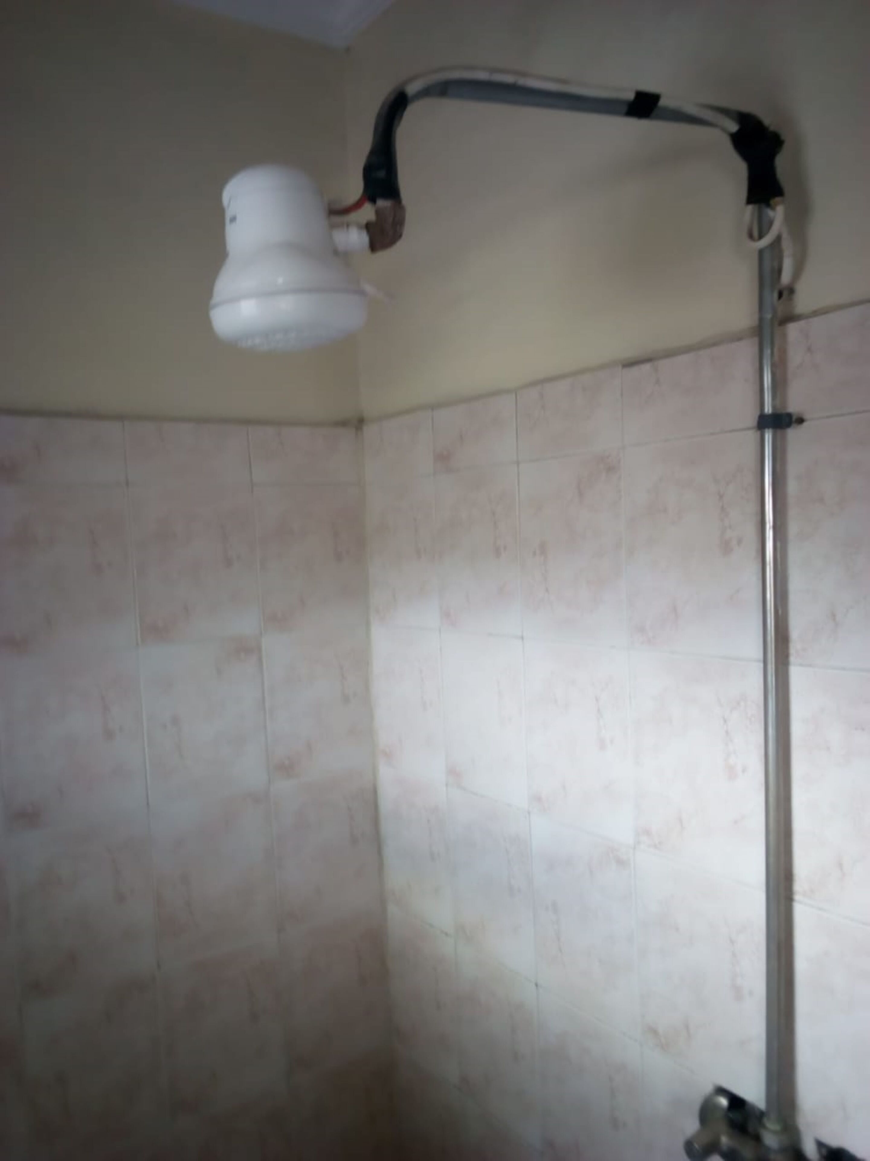 Una ducha con cabezal de ducha de mano fijado a la pared.