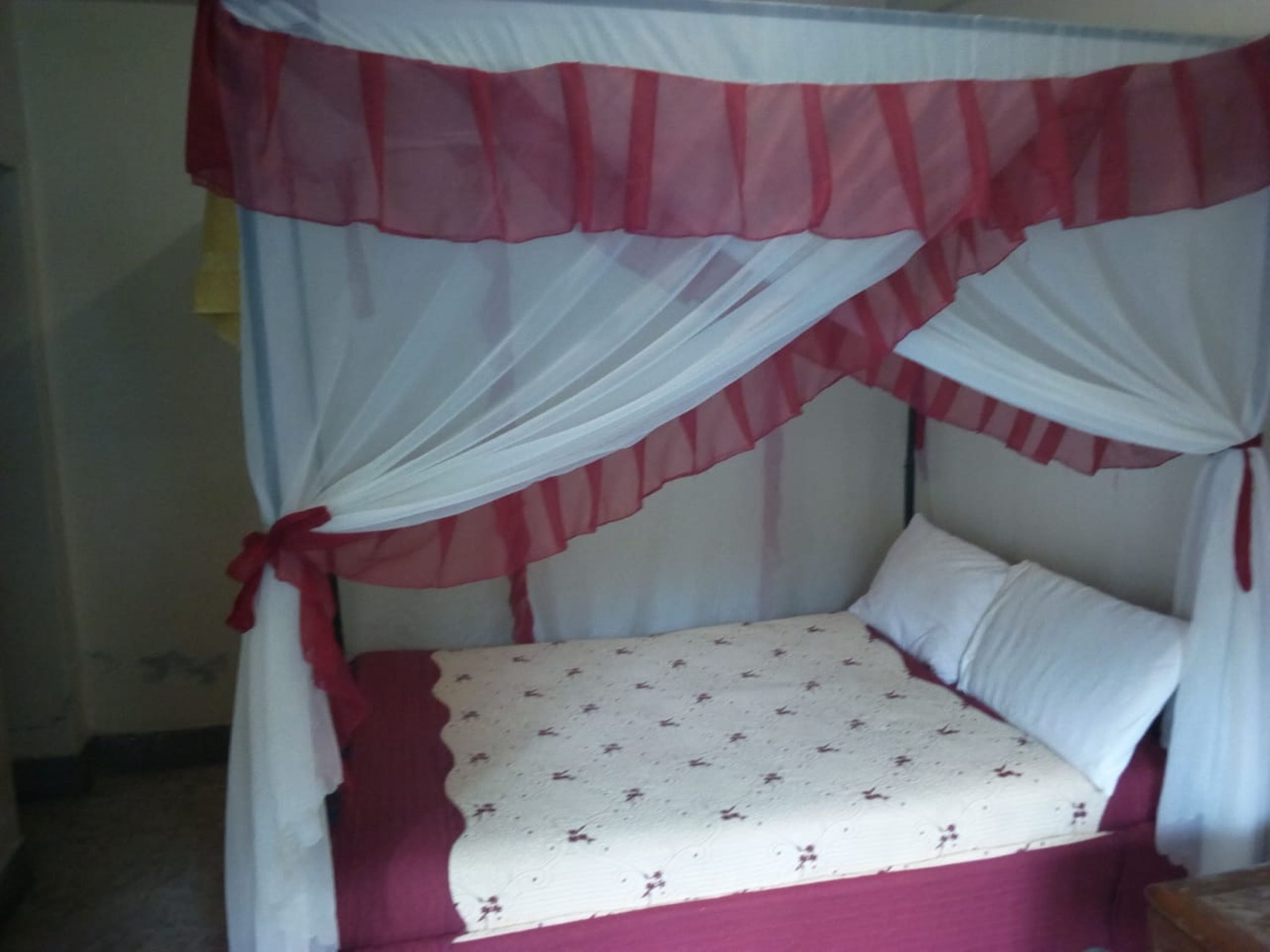 Un lit à baldaquin, une couvre-lit à motifs et un oreiller.
