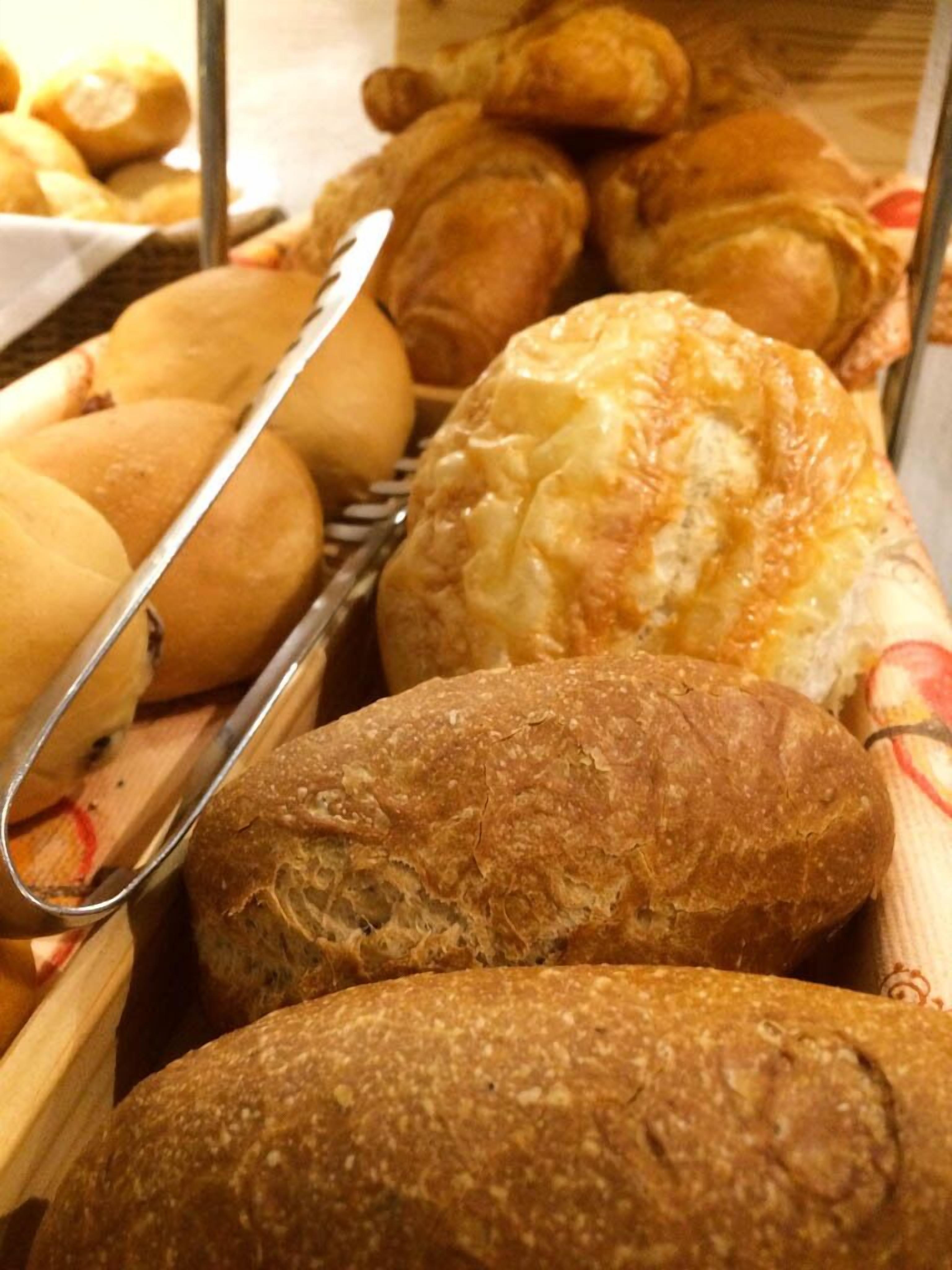 A variety of baked goods including bread and pastries in a display case.