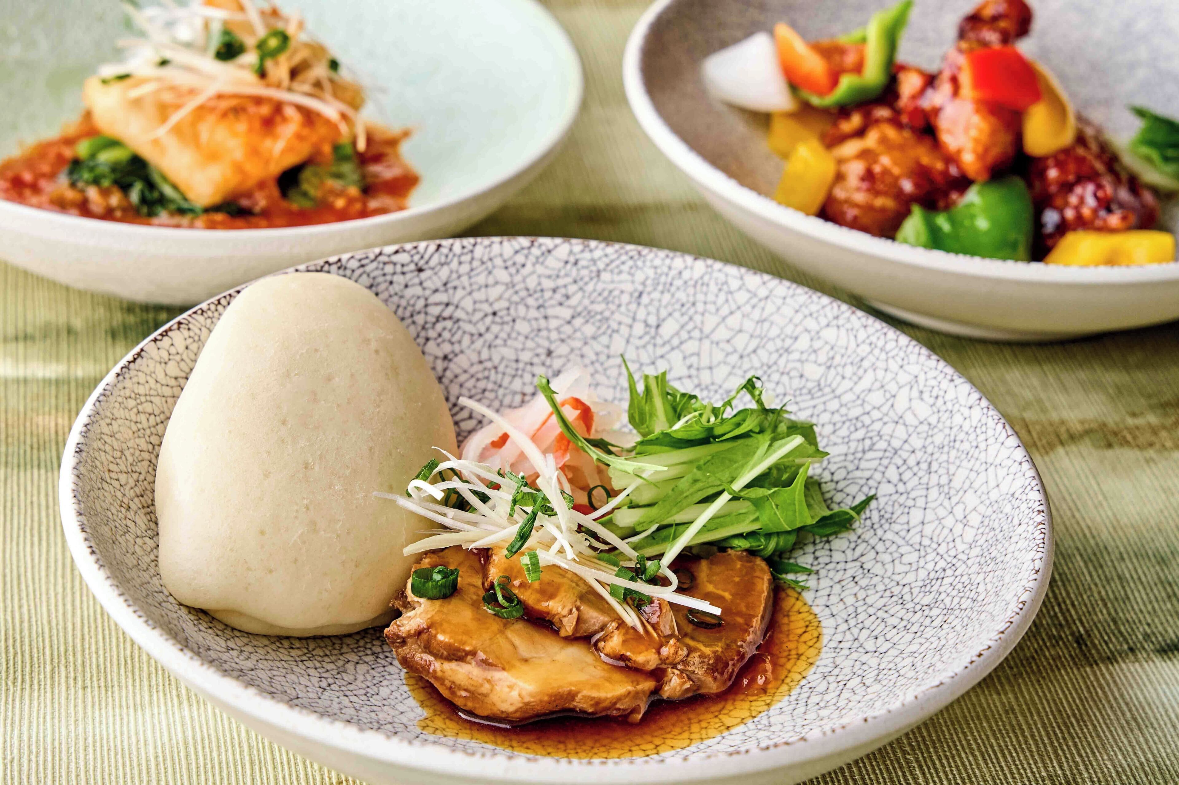A table with three dishes, each on a different plate.