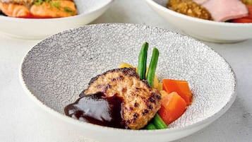 A plate with grilled meat, vegetables, and sauce.