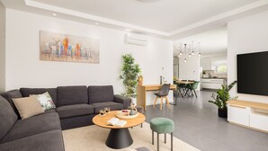Un salon moderne avec un canapé, une table basse et un coin repas.