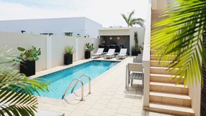 A swimming pool with lounge chairs and a staircase. - Palapa Suite # 2, walk to Eagle Beach (Oranjestad-West)