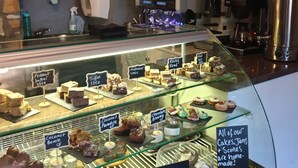 A bakery display case with various cakes and pastries, including gluten-free options. - The Covenanter Hotel (Cupar)