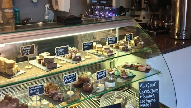 A bakery display case with various cakes and pastries, including gluten-free options. - The Covenanter Hotel (Cupar)