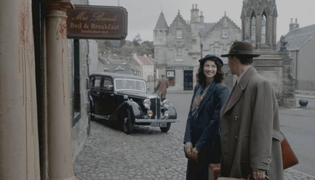 Un coche antiguo estacionado frente a un edificio con un letrero que dice 'Mrs. Brown's Bed & Breakfast'.