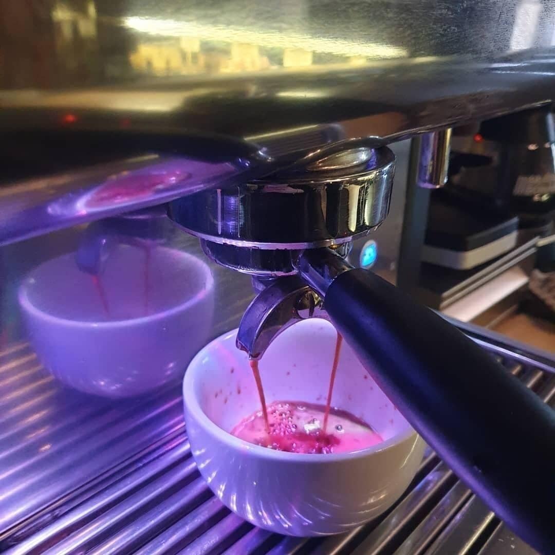Una máquina de café preparando un espresso en una taza.