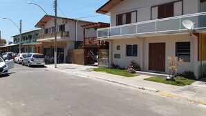 A residential street with houses, parked cars, and a clear sky. - Hotel Santa Rita (Capao da Canoa)