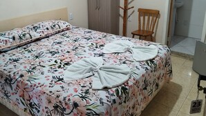 A bedroom with a bed, a wardrobe, a chair, and a bathroom visible through an open door. - Hotel Santa Rita (Capao da Canoa)