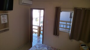 A room with a bed, a window with curtains, a wall-mounted air conditioner, and a sign on the wall. - Hotel Santa Rita (Capao da Canoa)