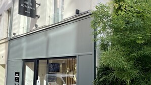 Entrada de hotel con un letrero que dice "HOTEL SO'MARAIS PARIS" y una puerta de cristal.