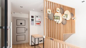 Un moderno vestíbulo de hotel con un separador de madera, una mesita y una cámara de seguridad instalada en la pared.
