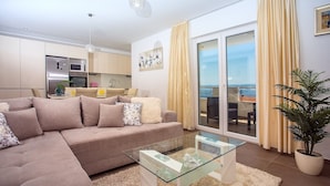 A modern living room with a sectional sofa, a glass coffee table, and a view of the sea through a sliding glass door. - Villa Dasianda - only 90 m from the beach, private 30msq heated pool (Stanici)
