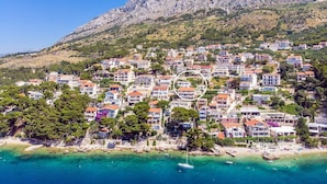 A coastal town with buildings clustered on a hillside, overlooking a clear blue sea. - Villa Dasianda - only 90 m from the beach, private 30msq heated pool (Stanici)