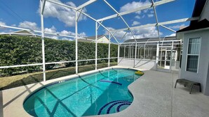 Une piscine extérieure dotée d’un bassin à eau claire et d’un système de jets, le tout entouré d’une structure en métal blanc.