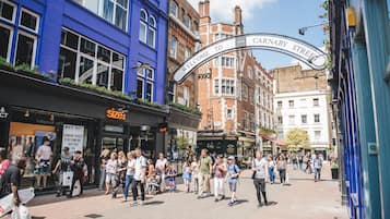 Cena movimentada de rua com um letreiro que diz 'Welcome to Carnaby Street'.