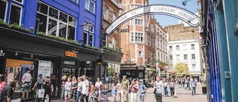 A busy street scene with a 'Welcome to Carnaby Street' sign.
