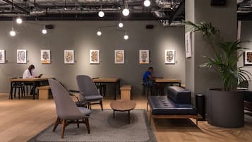 Ein modernes Interieur mit Holzböden, einem grauen Sofa, einem runden Couchtisch und einer großen Topfpflanze.