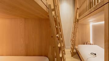 Habitación con literas, paredes de madera y una escalera.