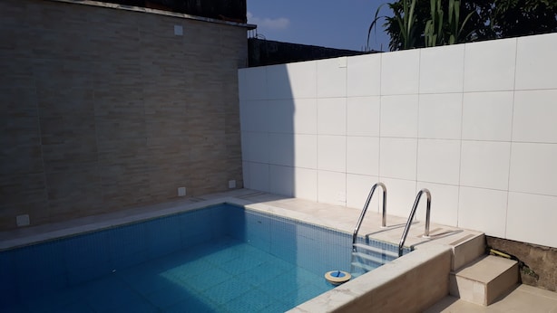 A rectangular swimming pool with a tiled edge and a metal ladder. - SEASON IN MONGAGUÁ (Balneario Itaguaí)