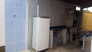 A kitchen with a tiled backsplash, a built-in oven, and a sink. - SEASON IN MONGAGUÁ (Balneario Itaguaí)