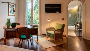 A dining area with a wooden table and chairs, a green vase, and a framed picture on the wall. - Casa Giotto (Padova)