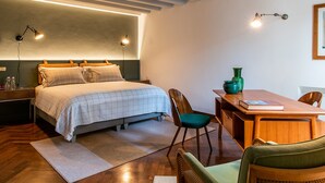 A bedroom with a bed, bedside tables, a desk, and chairs. - Casa Giotto (Padova)