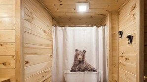 A wooden cabin bathroom with a bear-themed shower curtain. - Pet friendly/Hot tub/High speed internet/Location! (Sevierville)
