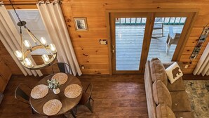 A cozy cabin interior with a wooden dining table, a sofa, and a chandelier. - Pet friendly/Hot tub/High speed internet/Location! (Sevierville)