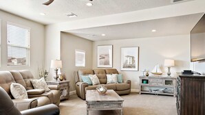 A spacious living room with leather sofas, a wooden coffee table, and a dark wooden cabinet. - Curtis Ladera RV PAD, Basketball Hoop, Community Pool (Washington)