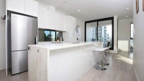 A modern kitchen with a large island, stainless steel appliances, and a minimalist design.