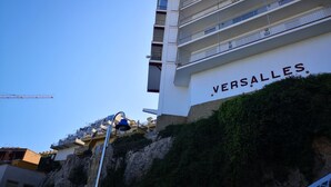 Un edificio de varios pisos con balcones y un letrero que dice "VERSALLES".