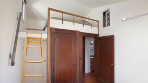 A bedroom with a loft bed, wooden ladder, and a closet with sliding doors. - Curtis Cottage · Berkeley Cottage, comfy, stylish, good wifi (Berkeley)