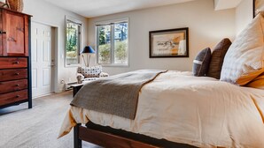 A bedroom with a bed, a dresser, a lamp, and a window with a view of greenery. - Family Condo w Mtn Views, walk to Gondola, SV22D (Vail)