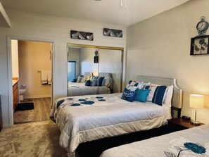 A bedroom with a bed, a bedside table with a lamp, a mirror, and a clock. - Paradise on Wolf Creek by Mesquite Vacation Rentals with Golf Course View and $510 in free daily activities (Mesquite)