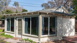 A small, single-story house with a covered porch and large windows. - Spotless Back House (Fresno)