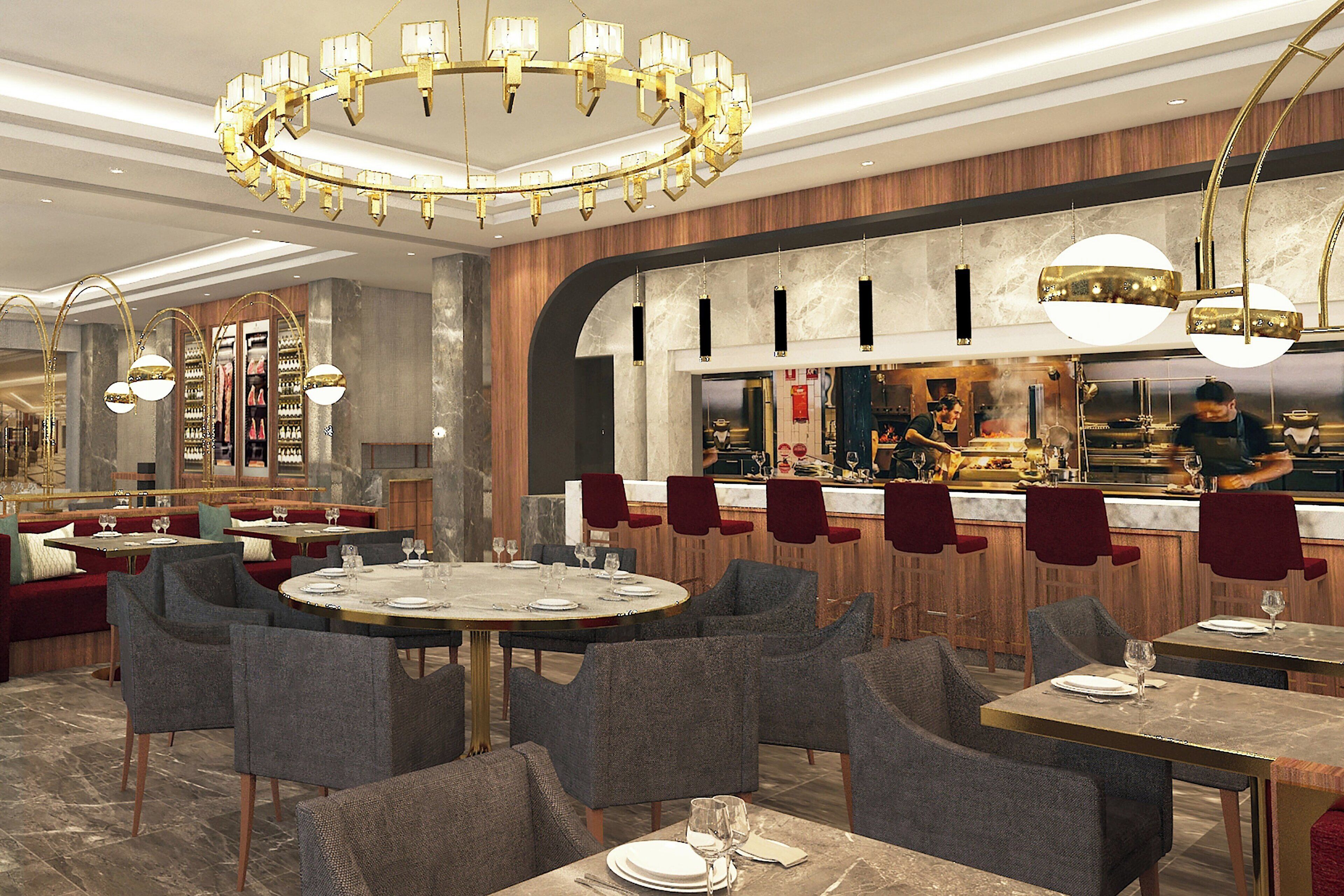 En moderne restaurant med runde borde, grå polstrede stole og et centralt barområde.