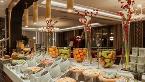 A buffet with various food items and decorative flowers. - Sheraton Bishkek (Bishkek)