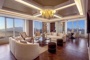 A spacious living room with a large window offering a mountain view, a chandelier, and a modern coffee table. - Sheraton Bishkek (Bishkek)