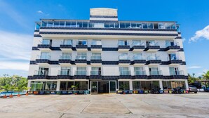A multi-story hotel with balconies, large windows, and a covered entrance. - Hotel Verony Guatape (Guatapé)