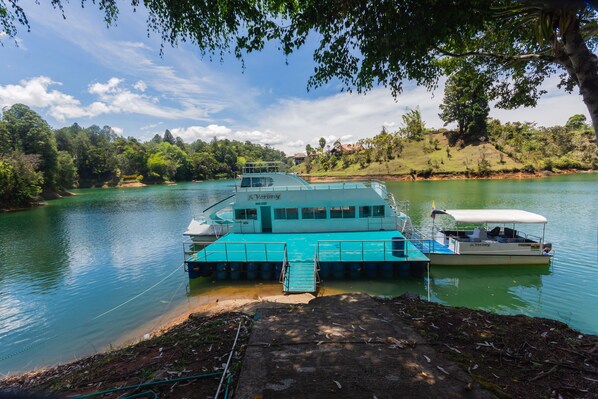 Un traversier accosta sur une rivière paisible, un quai s’étendant dans l’eau.