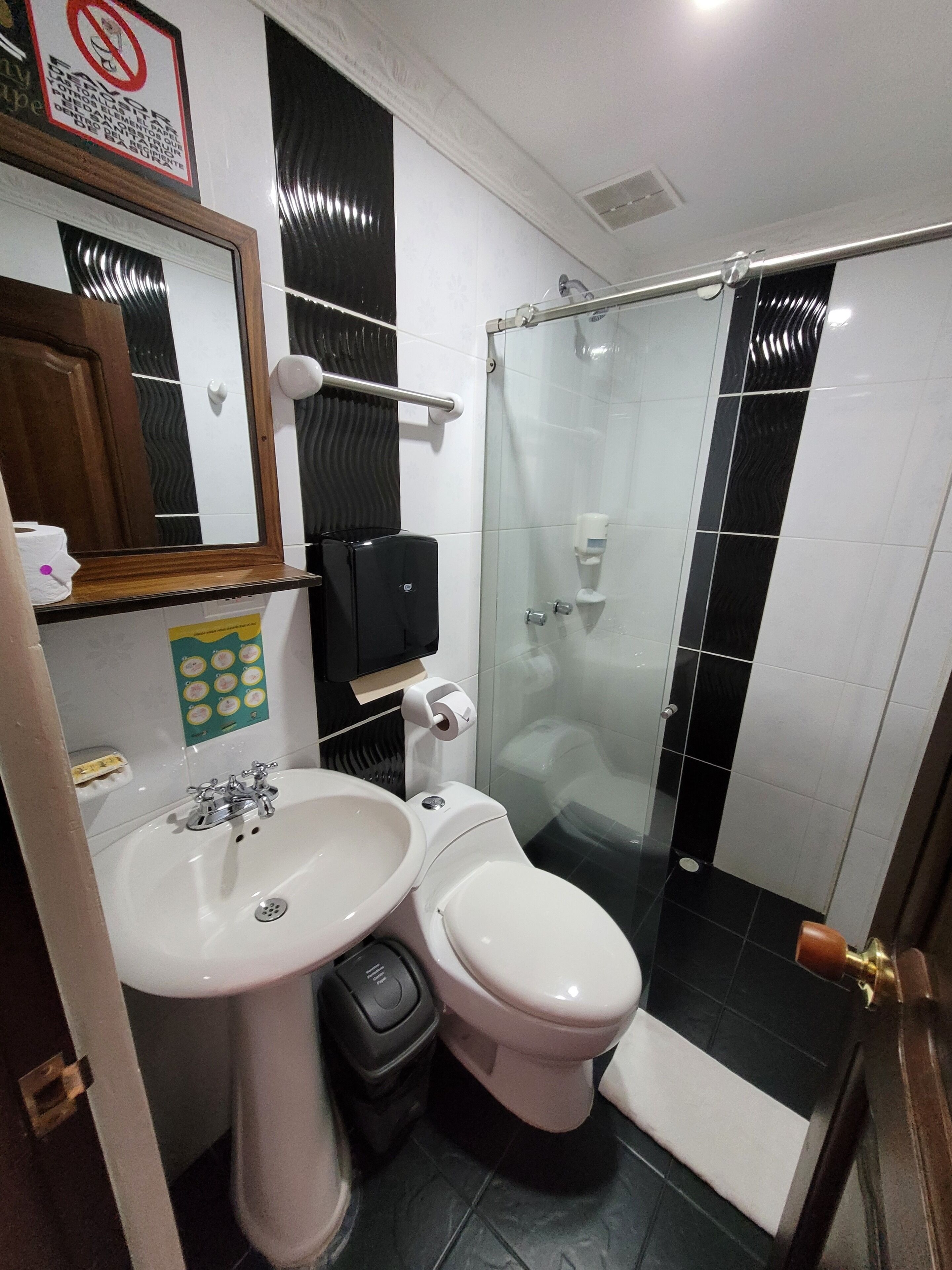 Un baño con lavamanos, inodoro y cabina de ducha de vidrio.