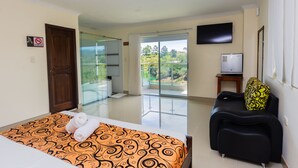 A hotel room with a bed, a sofa, a television, and a balcony with a view. - Hotel Verony Guatape (Guatapé)